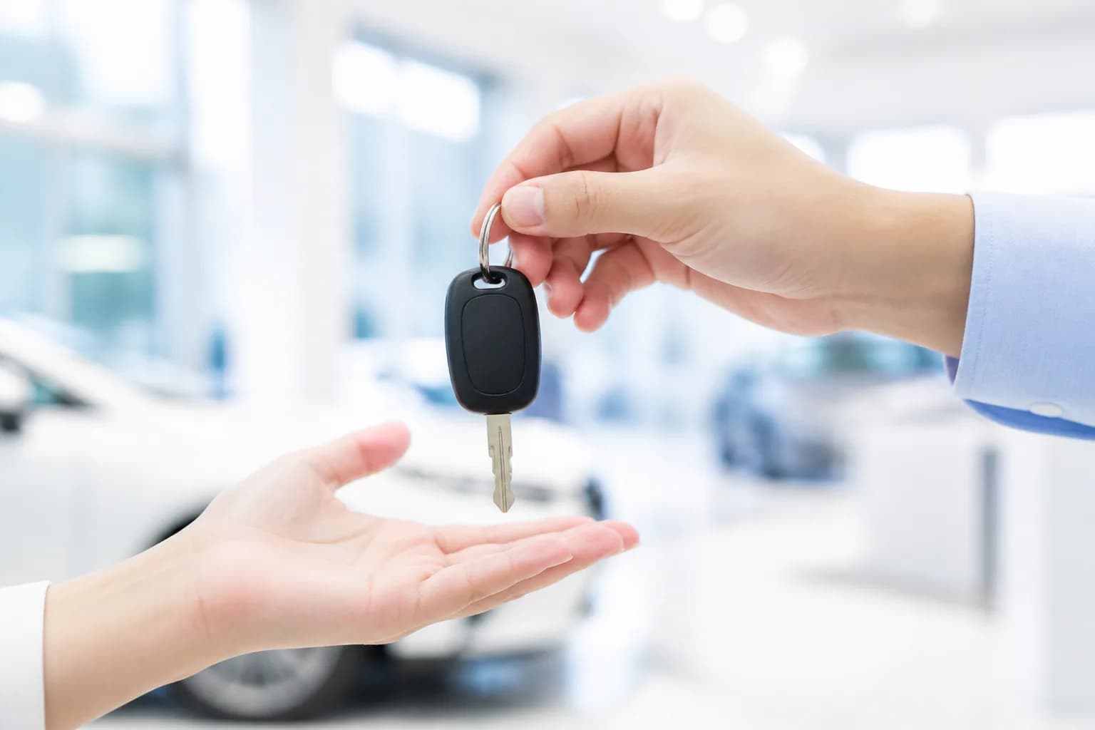 A car key passing from one pair of hands to another
